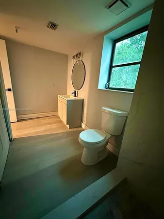 a bathroom with a toilet a sink and a window