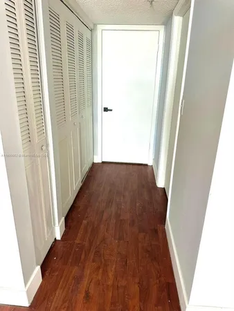 a view of a hallway with wooden floor and stairs