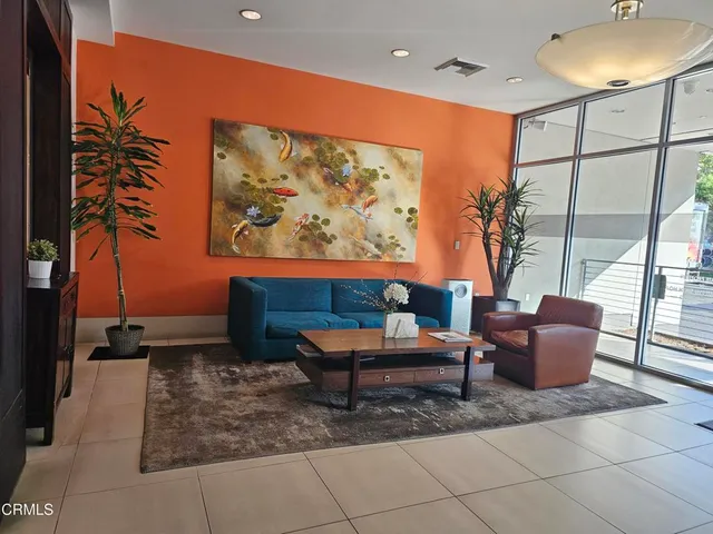 a living room with furniture and a painting on the wall