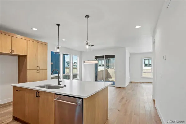 a kitchen with stainless steel appliances kitchen island wooden floors granite counter tops and a view of living room