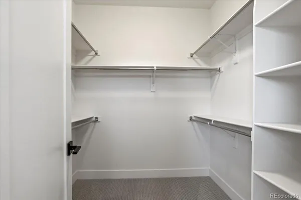 a view of an empty room with closet and a window