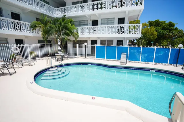 a view of a house with pool and chairs