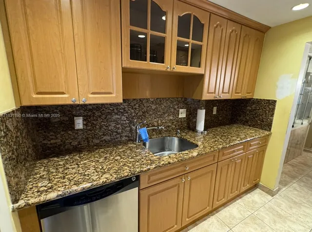 a kitchen with granite countertop cabinets and window