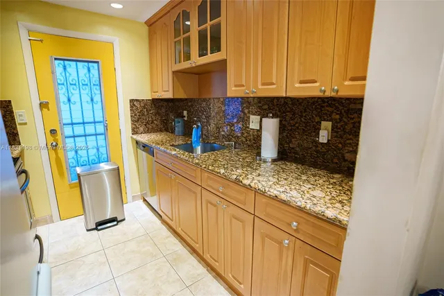 a kitchen with granite countertop cabinets and window