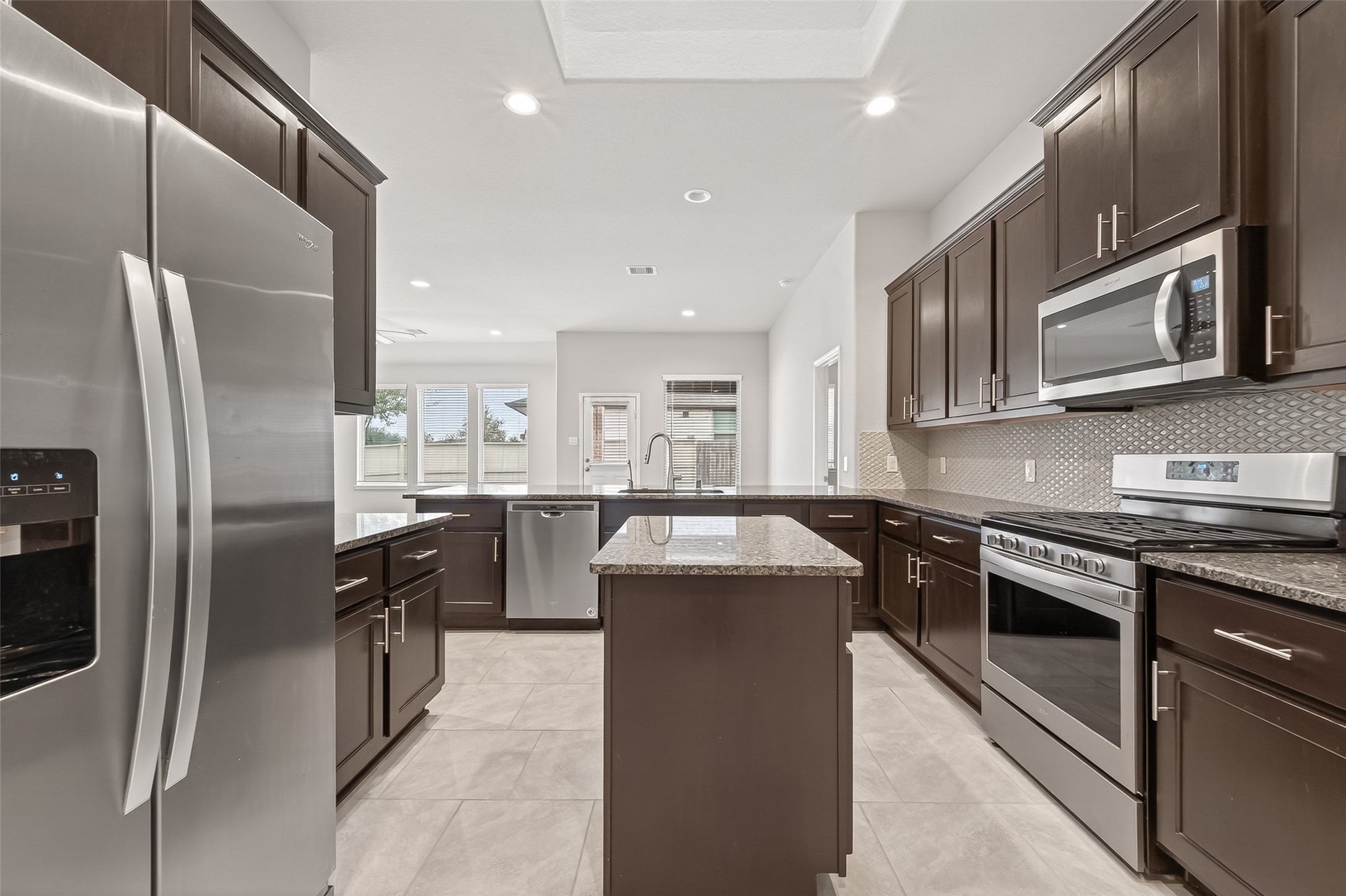 219 Verde Lake Way Rosenberg, TX 77469 - Photo 4 of 19 a kitchen with stainless steel appliances granite countertop a refrigerator a sink a stove top oven and cabinets