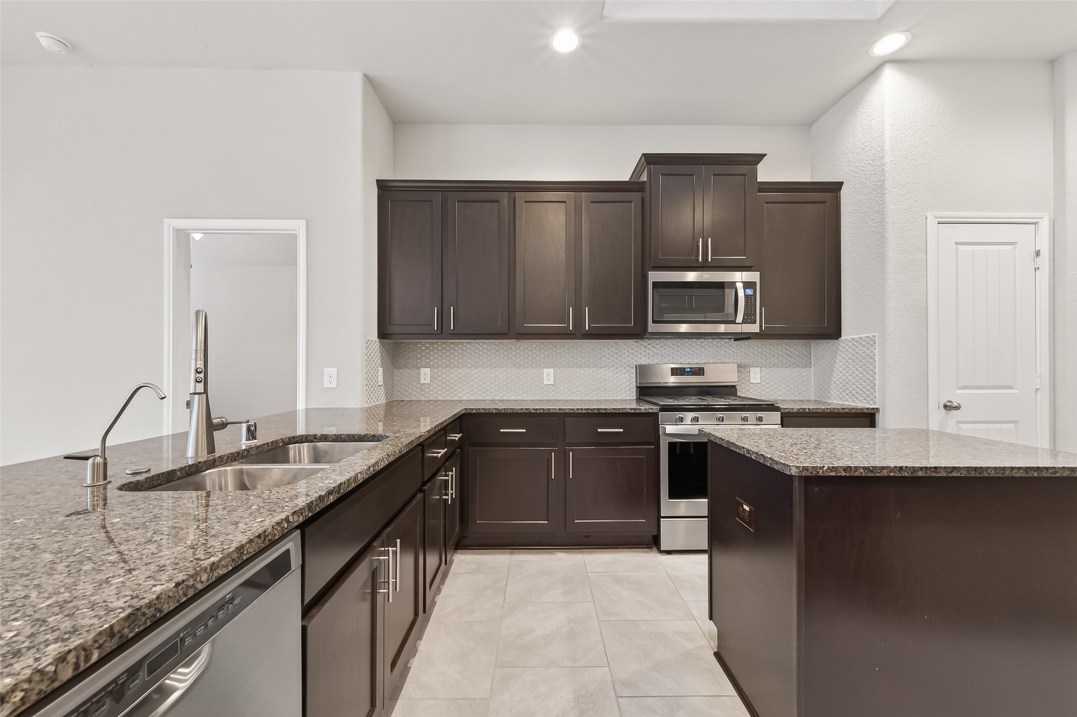219 Verde Lake Way Rosenberg, TX 77469 - Photo 6 of 19 a kitchen with stainless steel appliances granite countertop a sink stove and refrigerator