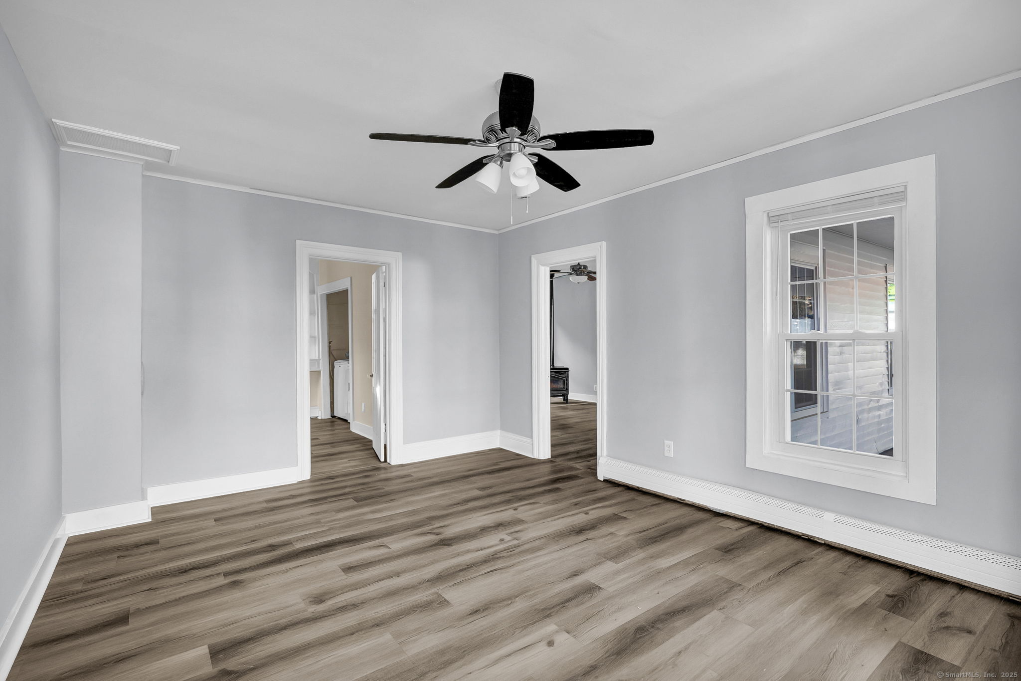 a view of empty room with wooden floor and window
