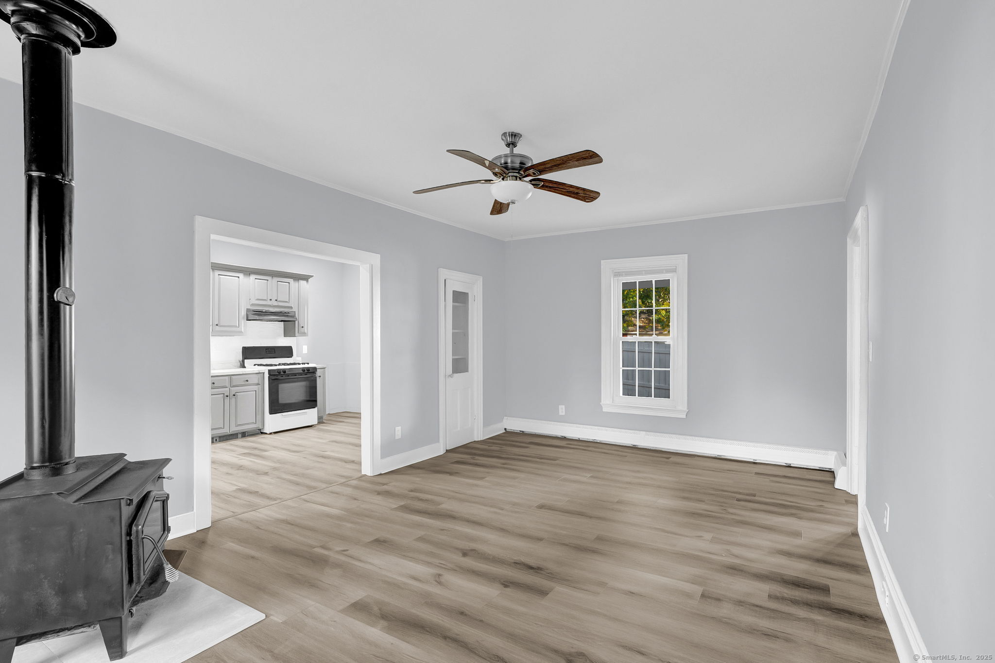 89 Spring Street Windham, CT 06226 - Photo 19 of 36 a view of an empty room with a window and wooden floor