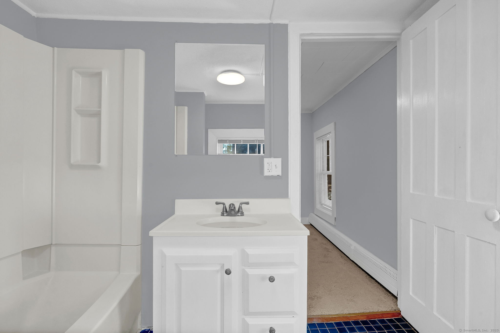 89 Spring Street Windham, CT 06226 - Photo 33 of 36 a bathroom with a bathtub sink vanity and mirror