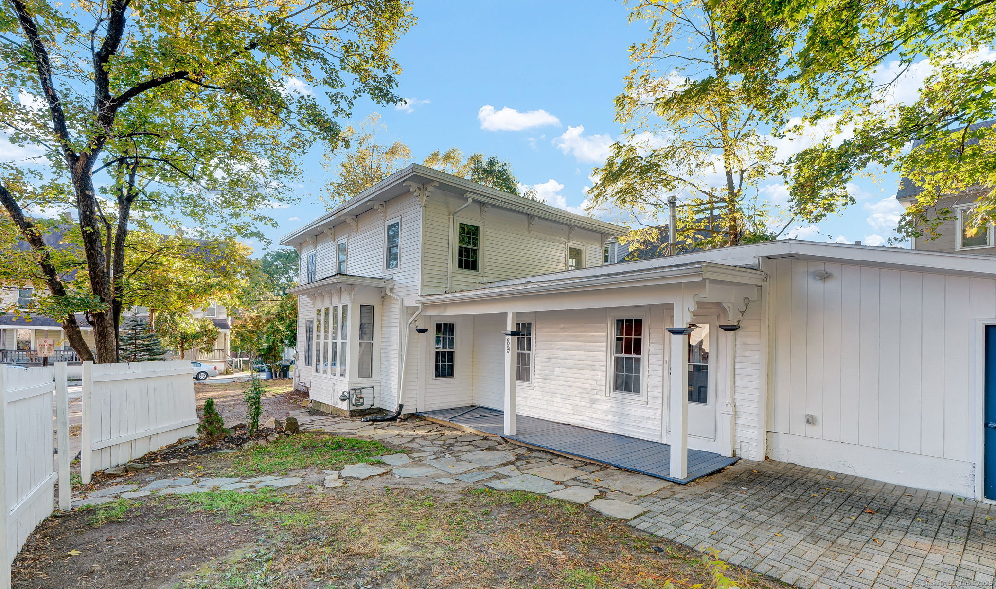89 Spring Street Windham, CT 06226 - Photo 5 of 36 a view of a white house with a yard and large tree