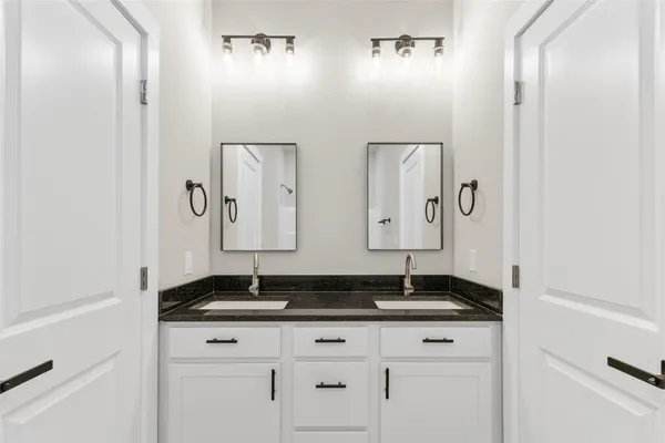 a bathroom with double sink and granite