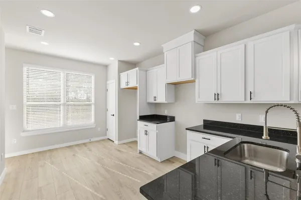 a kitchen that has a sink a stove and cabinets