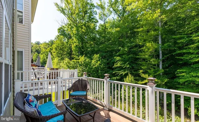 a view of a balcony with chairs and wooden fence