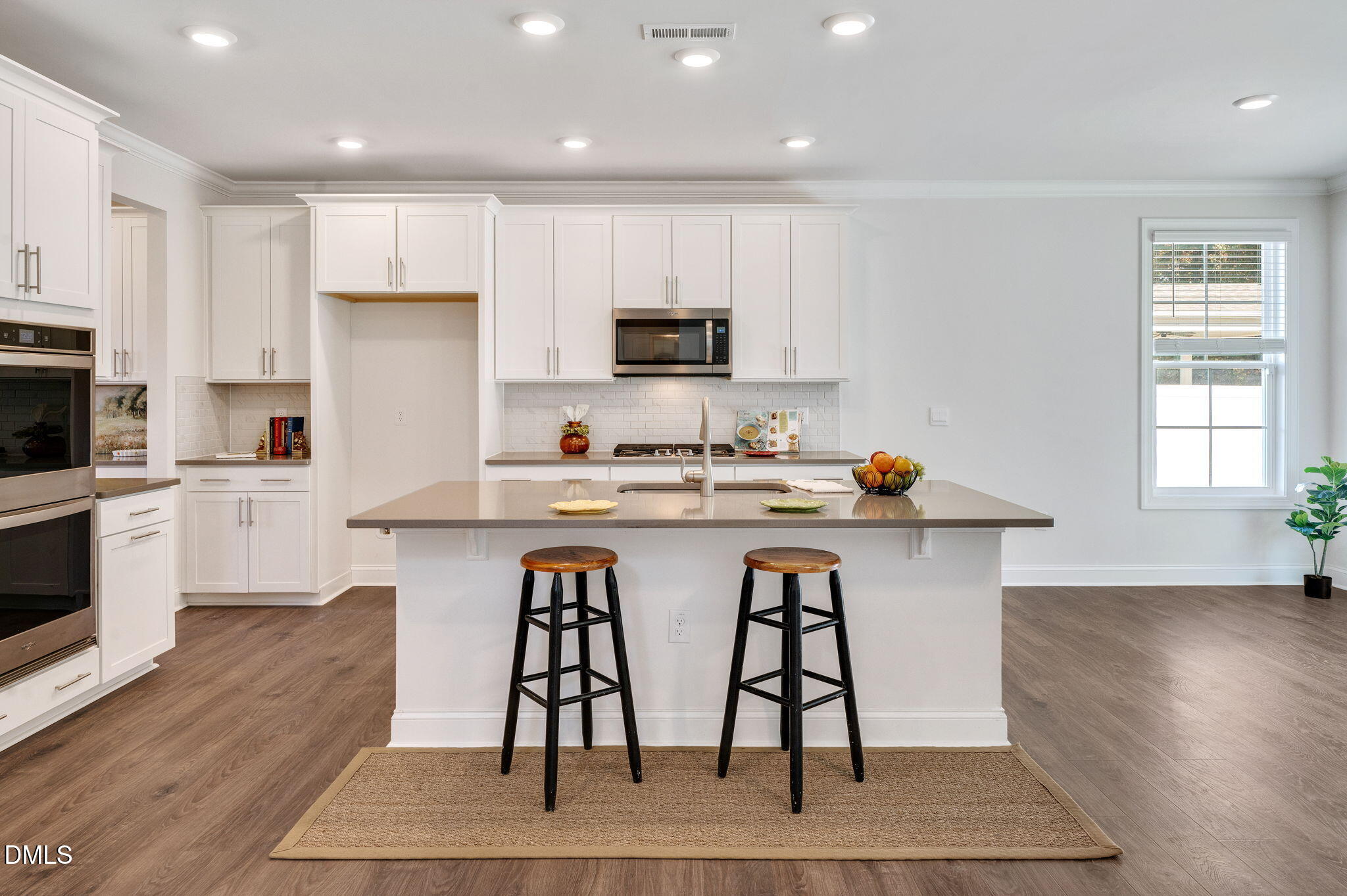 5112 Lizard Tail Lane Raleigh, NC 27603 - Photo 14 of 51 a kitchen with stainless steel appliances kitchen island granite countertop a table chairs sink and cabinets