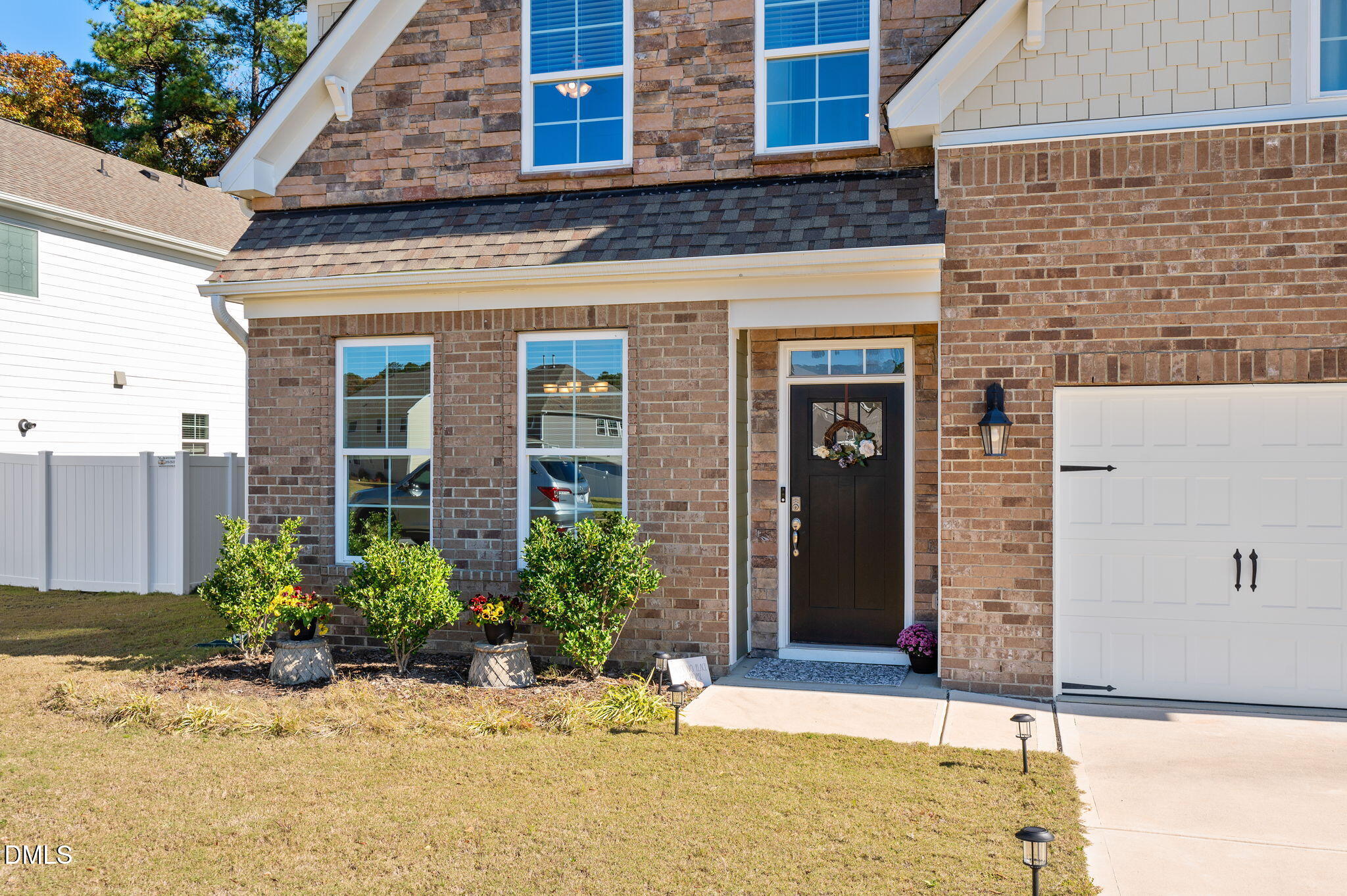 5112 Lizard Tail Lane Raleigh, NC 27603 - Photo 5 of 51 a view of a brick house with potted plants
