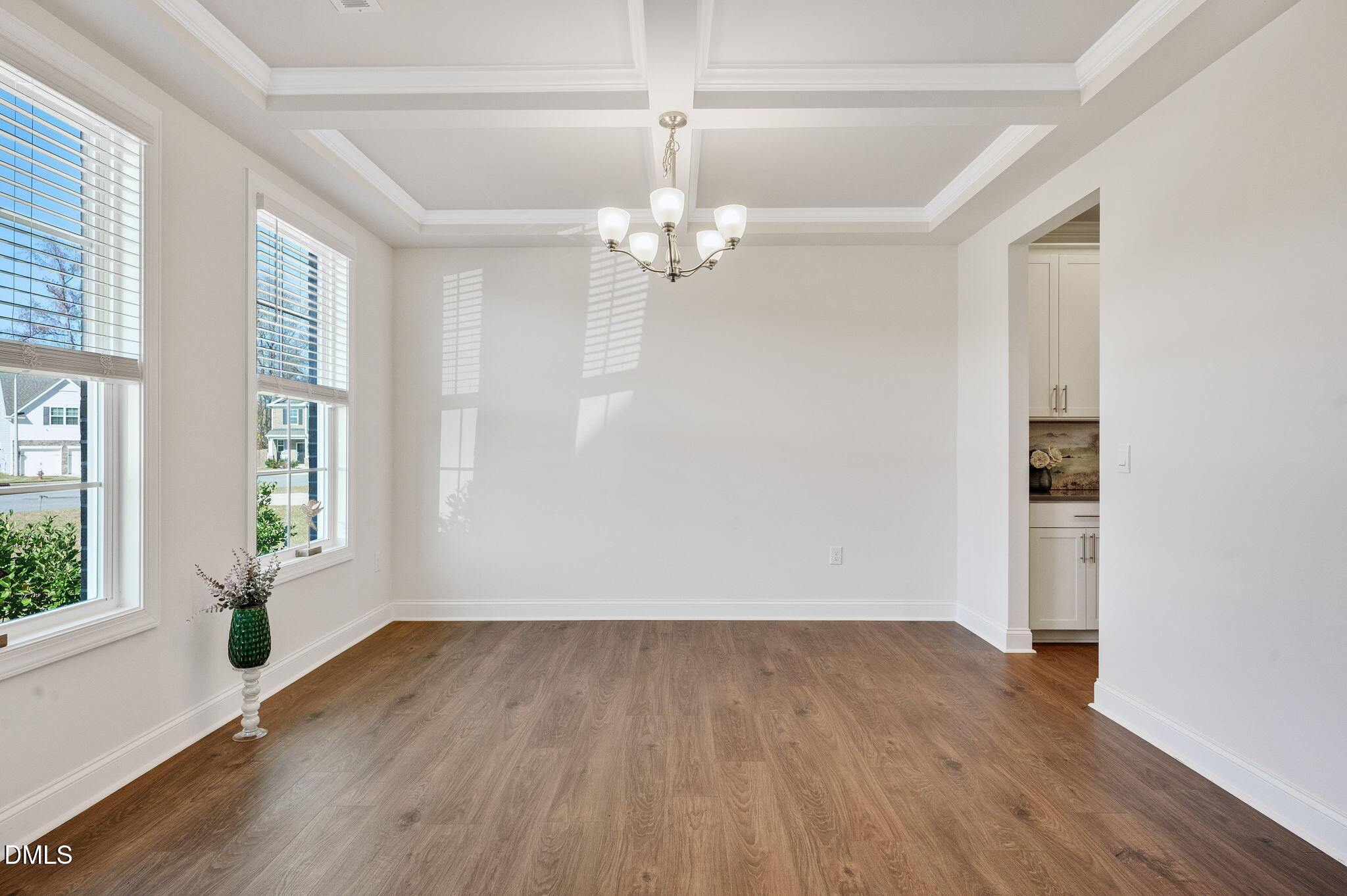 5112 Lizard Tail Lane Raleigh, NC 27603 - Photo 8 of 51 an empty room with wooden floor chandelier fan and windows
