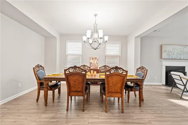 a view of a dining room with furniture a chandelier and wooden floor