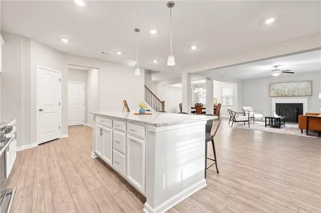 a large white kitchen with lots of counter space a sink and a large refrigerator