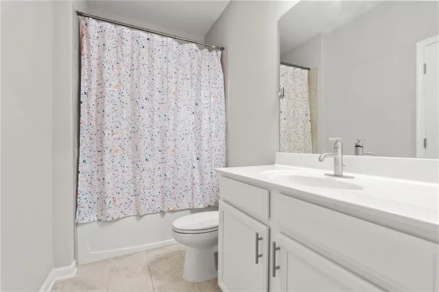 a bathroom with a sink a toilet and shower curtain