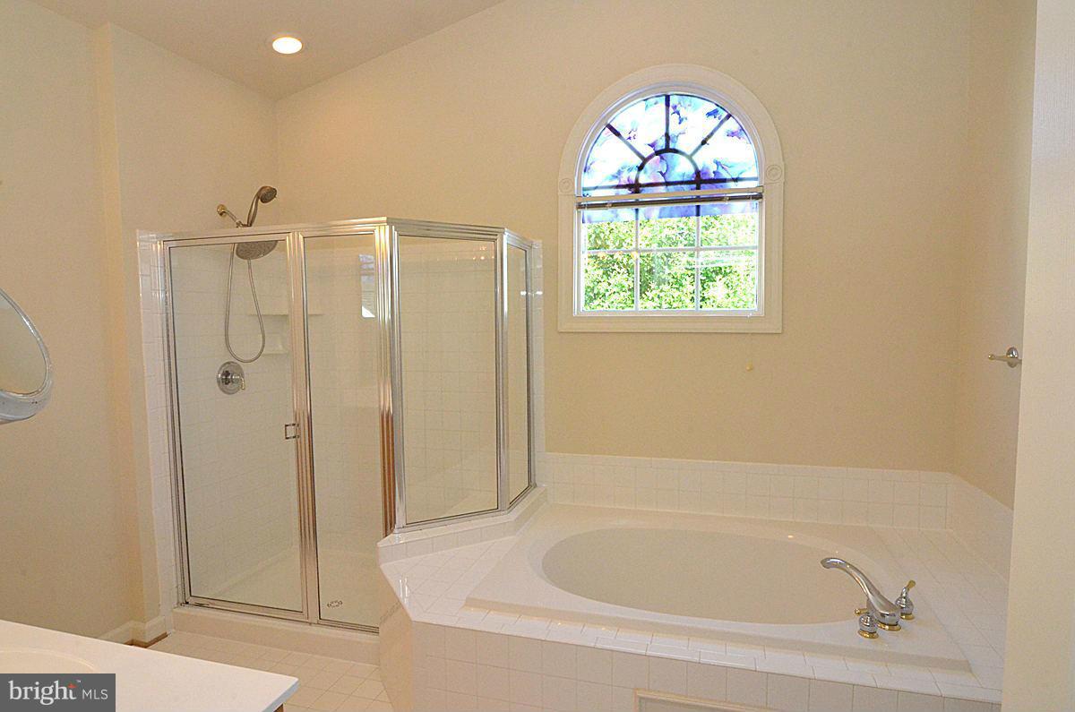 23506 Clarksburg Road Clarksburg, MD 20871 - Photo 16 of 29 a bathroom with a bathtub and a shower
