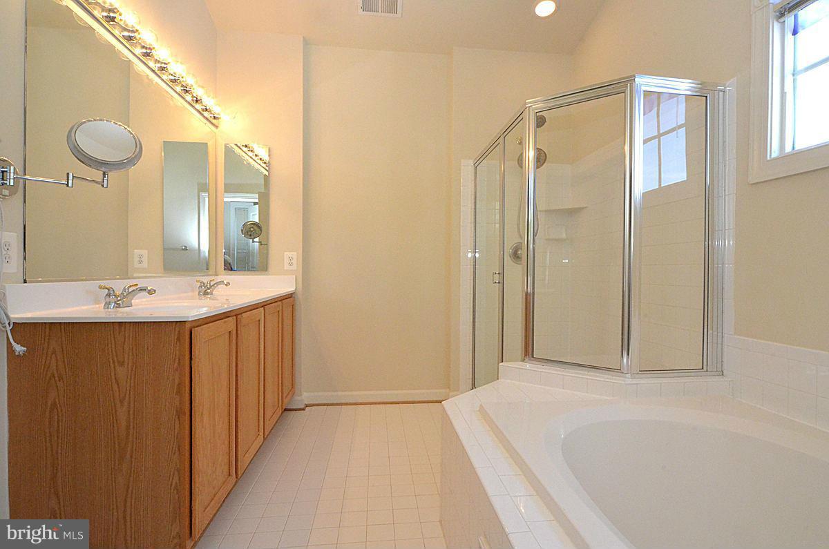 23506 Clarksburg Road Clarksburg, MD 20871 - Photo 17 of 29 a bathroom with a bathtub a sink and a mirror