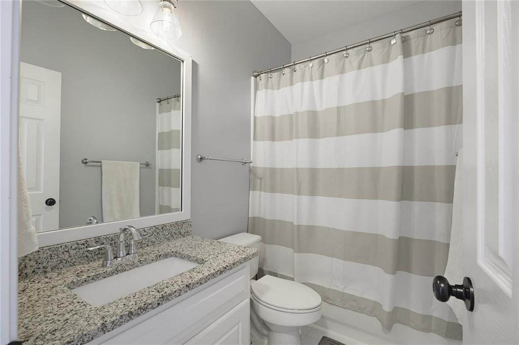 14442 Club Circle Milton, GA 30004 - Photo 41 of 82 a bathroom with a granite countertop sink a toilet a mirror a shower and a mirror