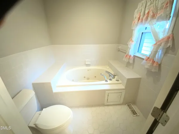 a white bath tub sitting next to a white toilet