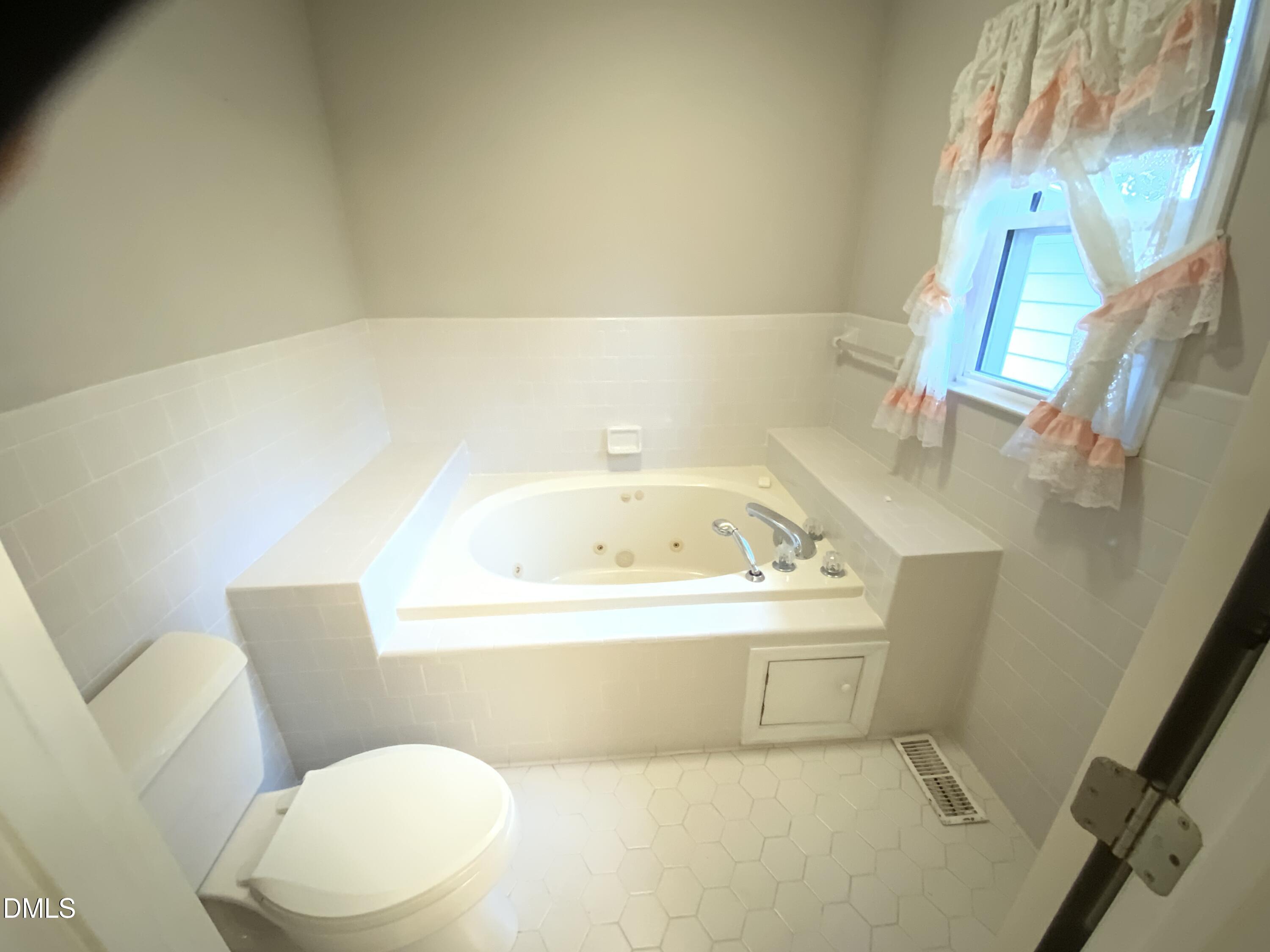 100 East C Street Erwin, NC 28339 - Photo 11 of 21 a white bath tub sitting next to a white toilet