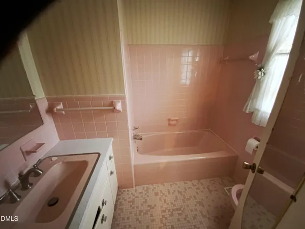 a bathroom with a tub sink and toilet