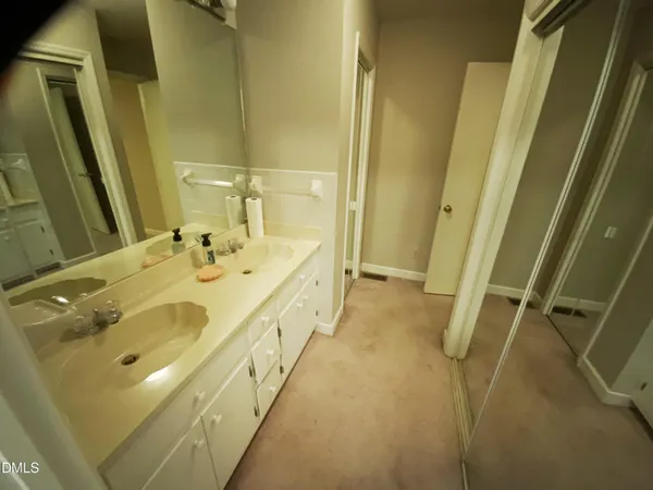 a spacious bathroom with a double vanity sink and a mirror