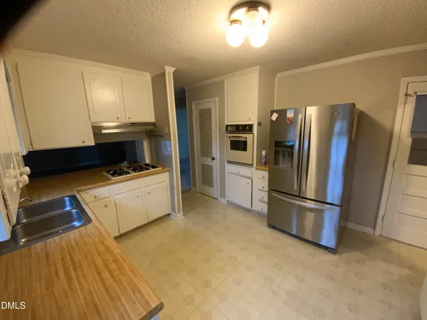 a kitchen with a refrigerator and a stove top oven