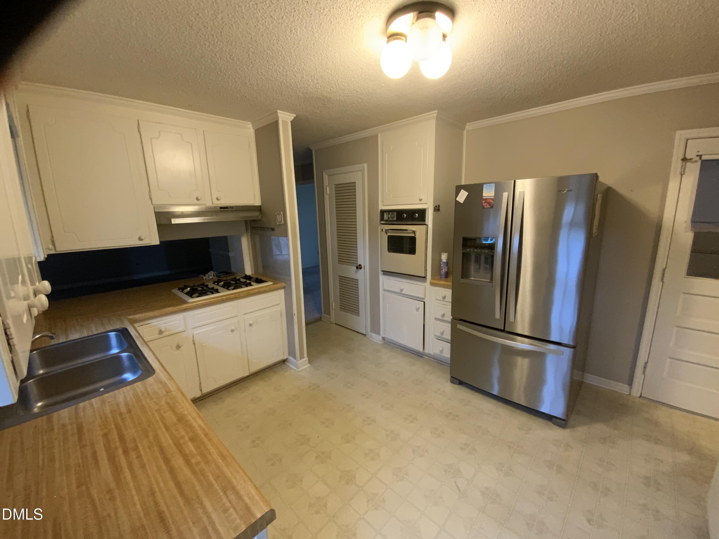 100 East C Street Erwin, NC 28339 - Photo 3 of 21 a kitchen with a refrigerator and a stove top oven