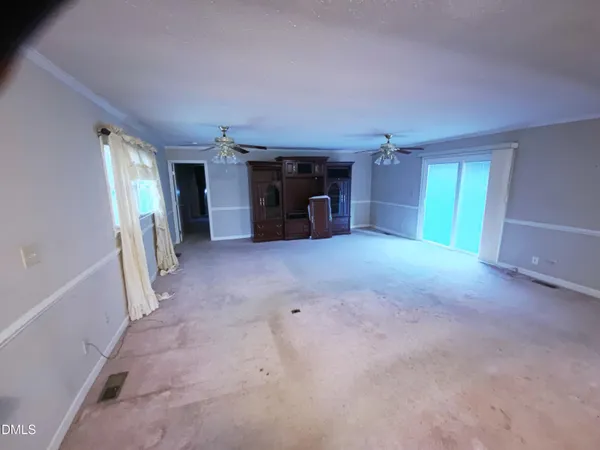 a view of empty room with furniture and a window