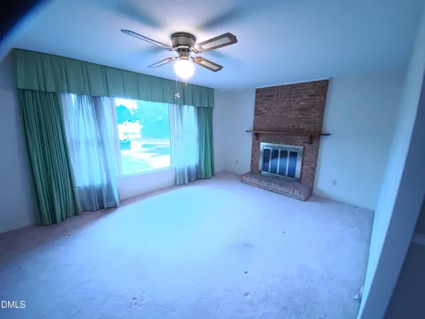 a view of empty room with a fireplace and fan
