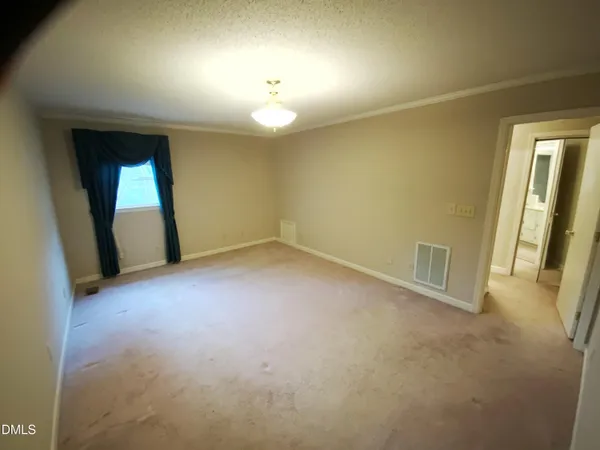 an empty room with a mirror and a window