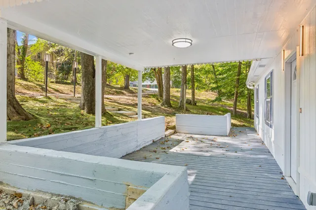 a view of an empty room with wooden floor and a large window