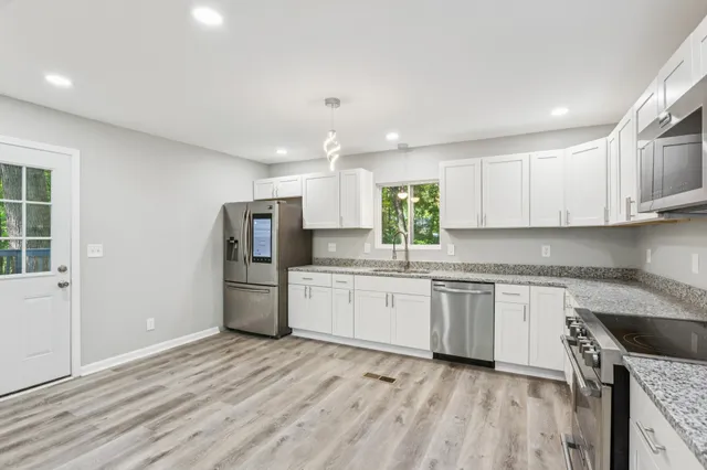 a kitchen with a sink a refrigerator and window
