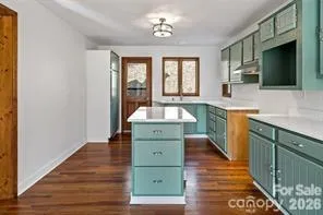 a kitchen with a sink and a wooden floor