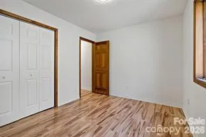 a view of a room with wooden floor and closet