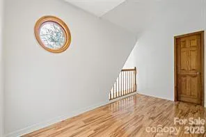 an empty room with a window and wooden floor