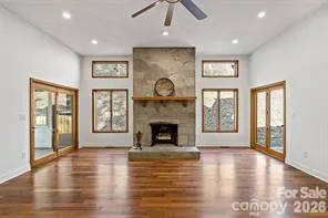 a view of an empty room with glass door and wooden floor