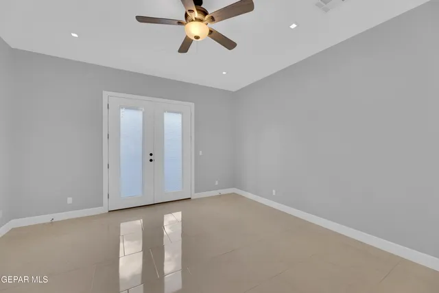 an empty room with window and ceiling fan