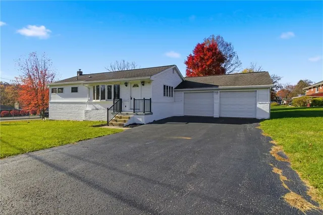 a front view of house with yard and green space