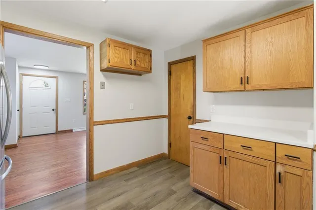 a view of a kitchen with wooden floor and cabinets