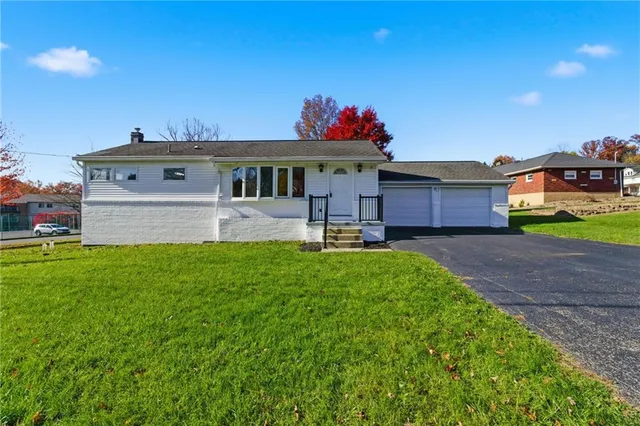 a front view of a house with a yard and a garage