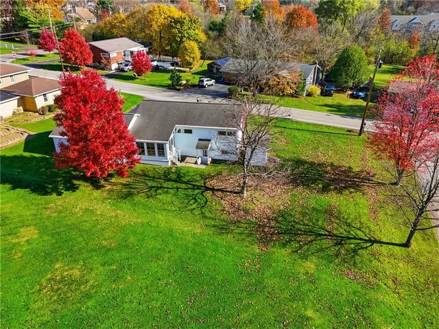 a view of a house with a big yard and potted plants