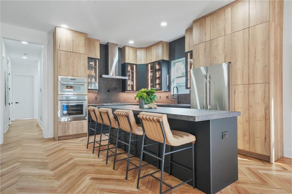 718 Cascade Avenue Southwest Atlanta, GA 30310 - Photo 18 of 37 a kitchen with stainless steel appliances granite countertop a table chairs in it and wooden floors