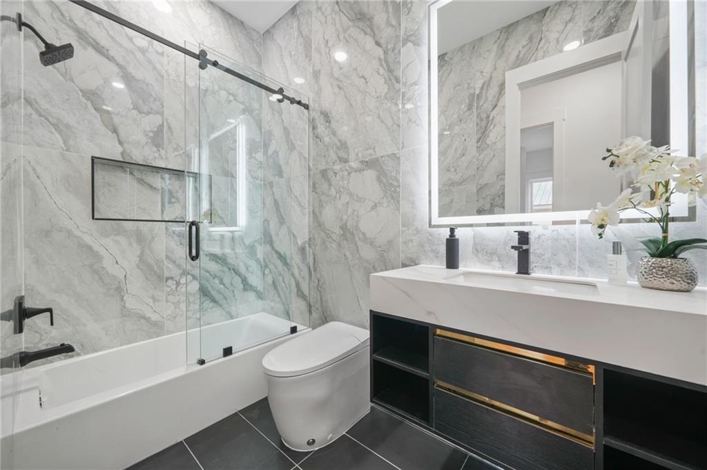 718 Cascade Avenue Southwest Atlanta, GA 30310 - Photo 24 of 37 a bathroom with a bathtub shower sink vanity and toilet