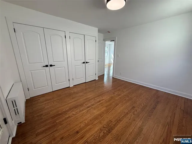 a view of an empty room and wooden floor