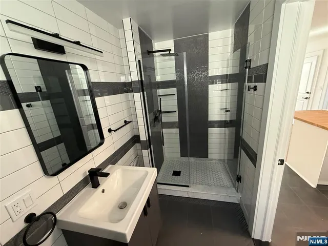 a bathroom with a sink a mirror and shower